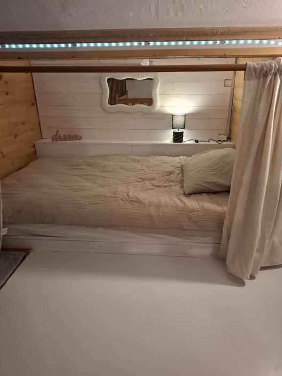 a large bed in a room with a light on it at Appartament prés de la mer in Valras-Plage