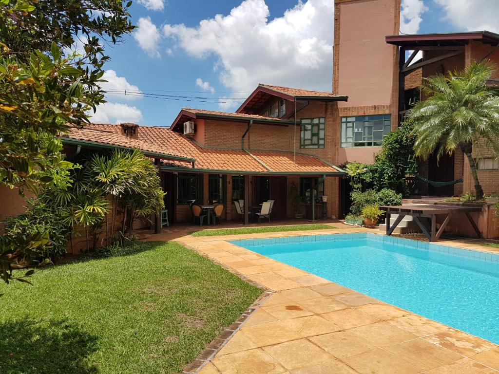 a house with a swimming pool in front of a house at Casa Com Piscina in Campinas