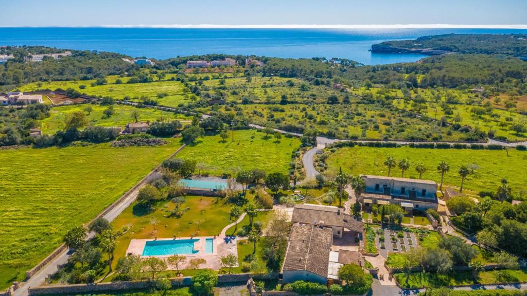 an aerial view of a house with a field and water at Agroturismo Mondrago -Antic Na Martina- in Portopetro