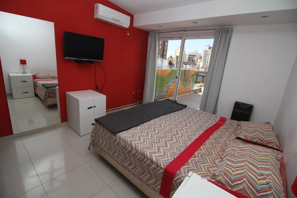 1 dormitorio con 1 cama y TV de pantalla plana en Link Cordoba Hostel en Córdoba