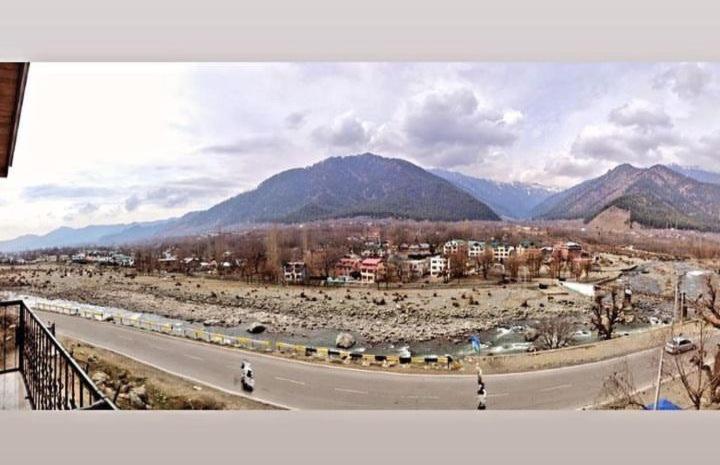 a view of a road with mountains in the background at Hotel castle rock in Pahalgām