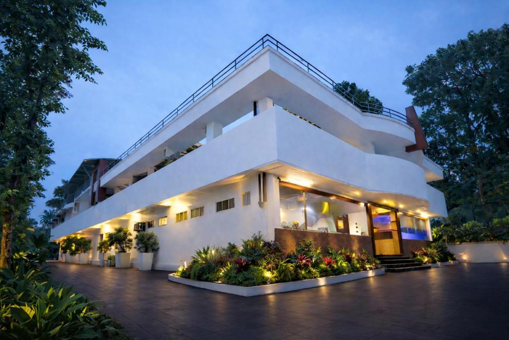 a large white building with flowers in front of it at Hotel Indraprastha varkala in Varkala