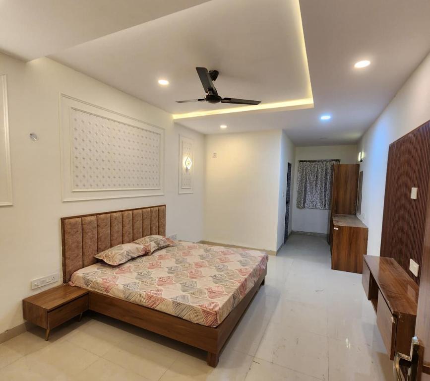 a bedroom with a bed and a ceiling fan at Omisha Stay & Pavilion in Sehore