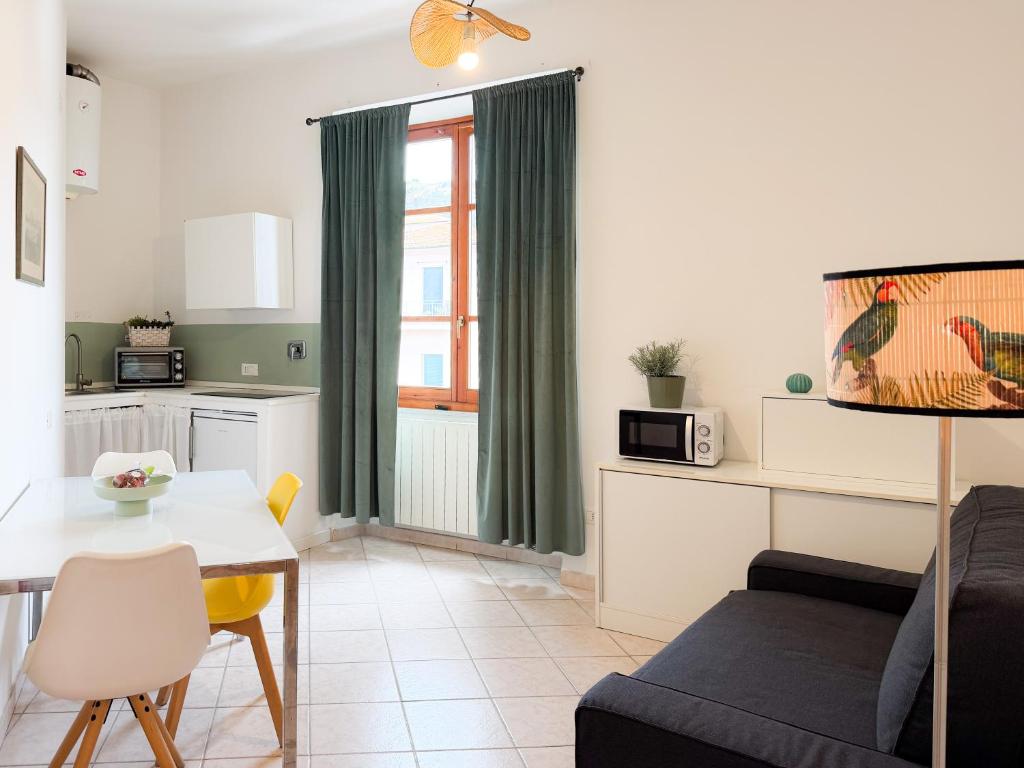 a kitchen and living room with a table and a couch at Ponticello Mare - HelloElba in Portoferraio