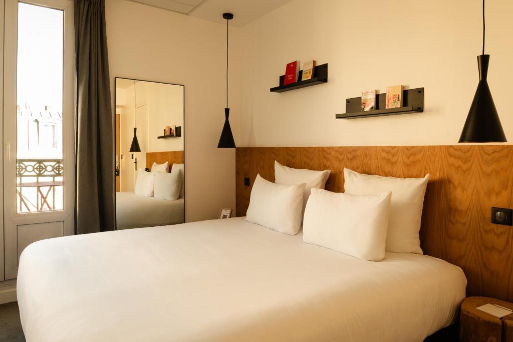 a bedroom with a large bed with white pillows at 9Hotel Bastille-Lyon in Paris