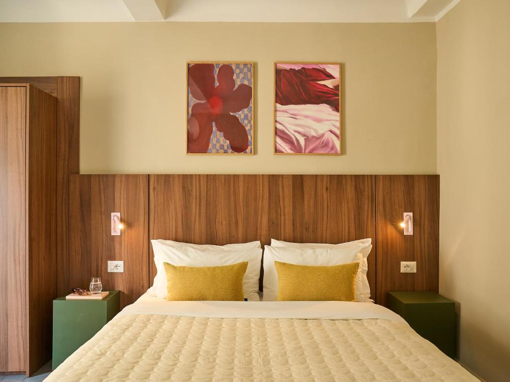 a bedroom with a bed and two paintings on the wall at Numa Florence Rodo in Florence
