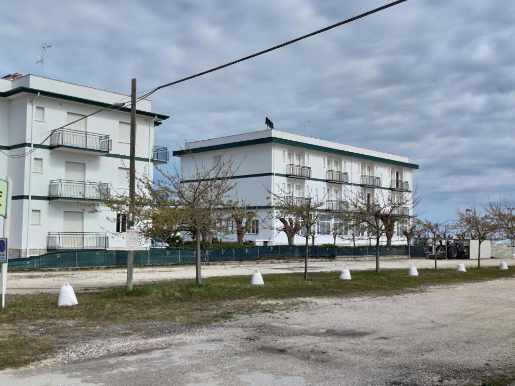 a large white building with trees in front of it at vacanza in appartamento sul mare in Fano