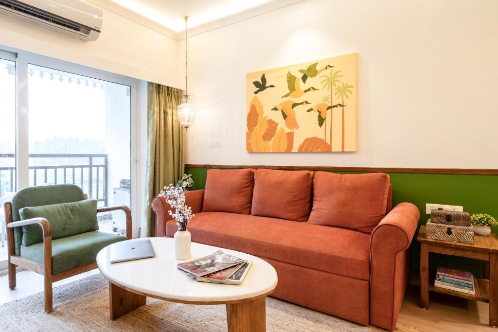 a living room with a couch and a table at Staymaster Encanto - Serviced 2BHK in Siolim