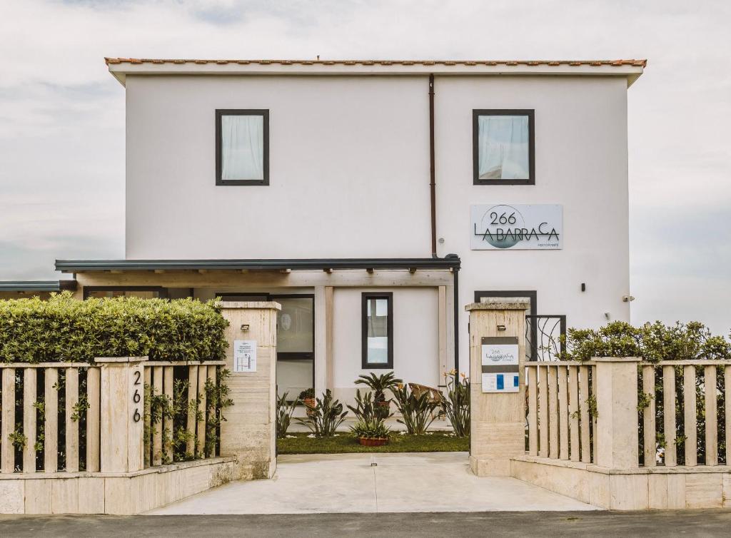 a white house with a gate and a fence at 266 La Barraca in Torvaianica