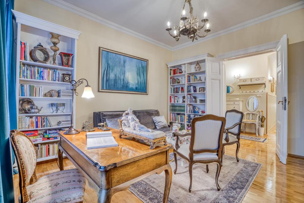 a living room with a table and chairs and bookshelves at Apartament ASSER - 110 m2 komfortu in Pszczyna