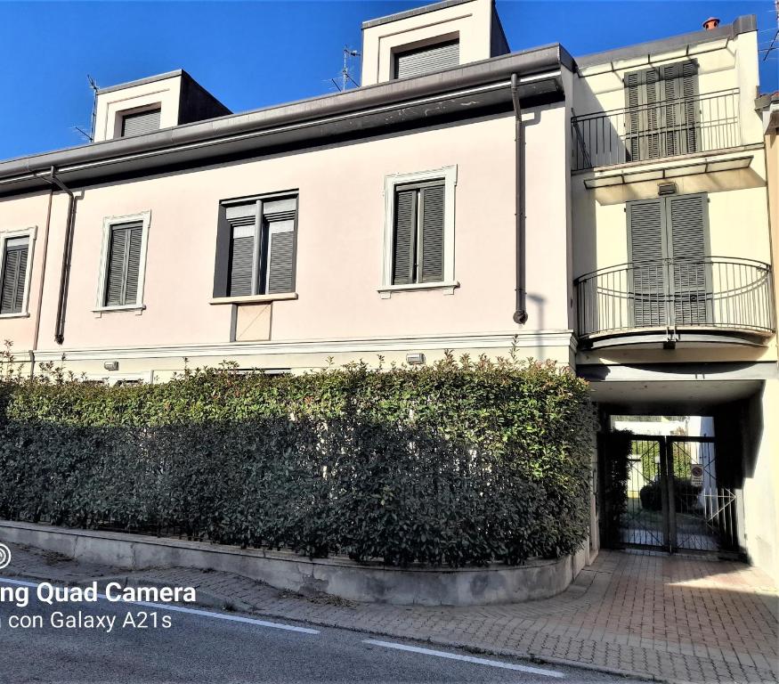 a white building with a hedge in front of it at host di Elena in Lesmo