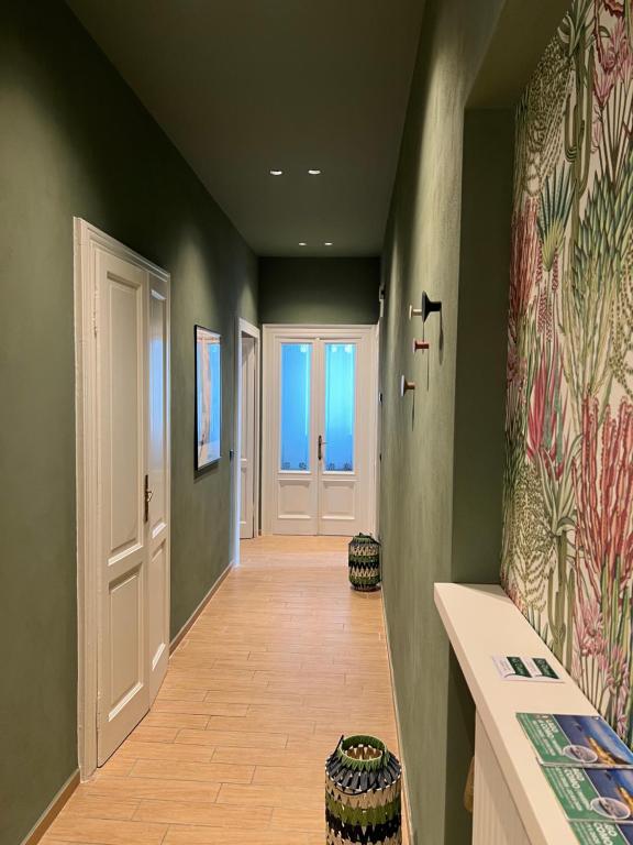 a hallway with green walls and a white door at Appartamento Nicole 20 in Menaggio