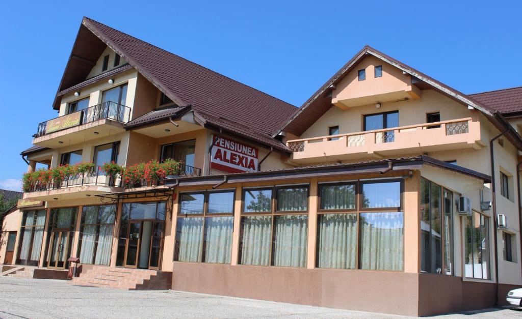 a building with a sign in front of it at Pensiunea Alexia in Bistriţa