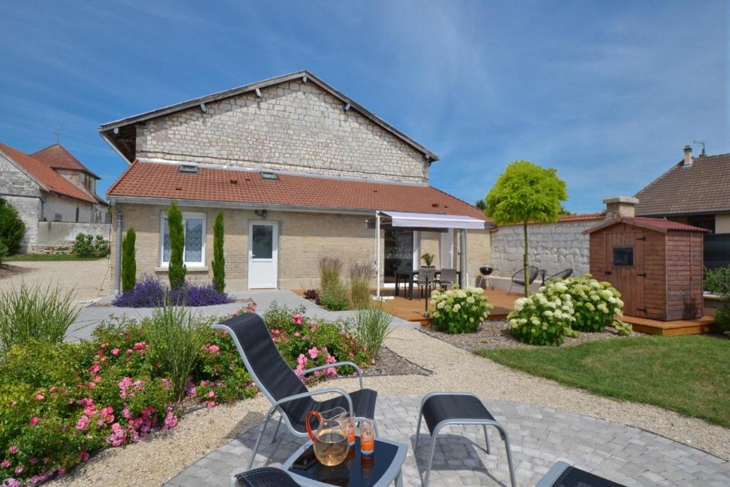 a patio with a table and chairs in front of a house at Pause campagne in Fagnières