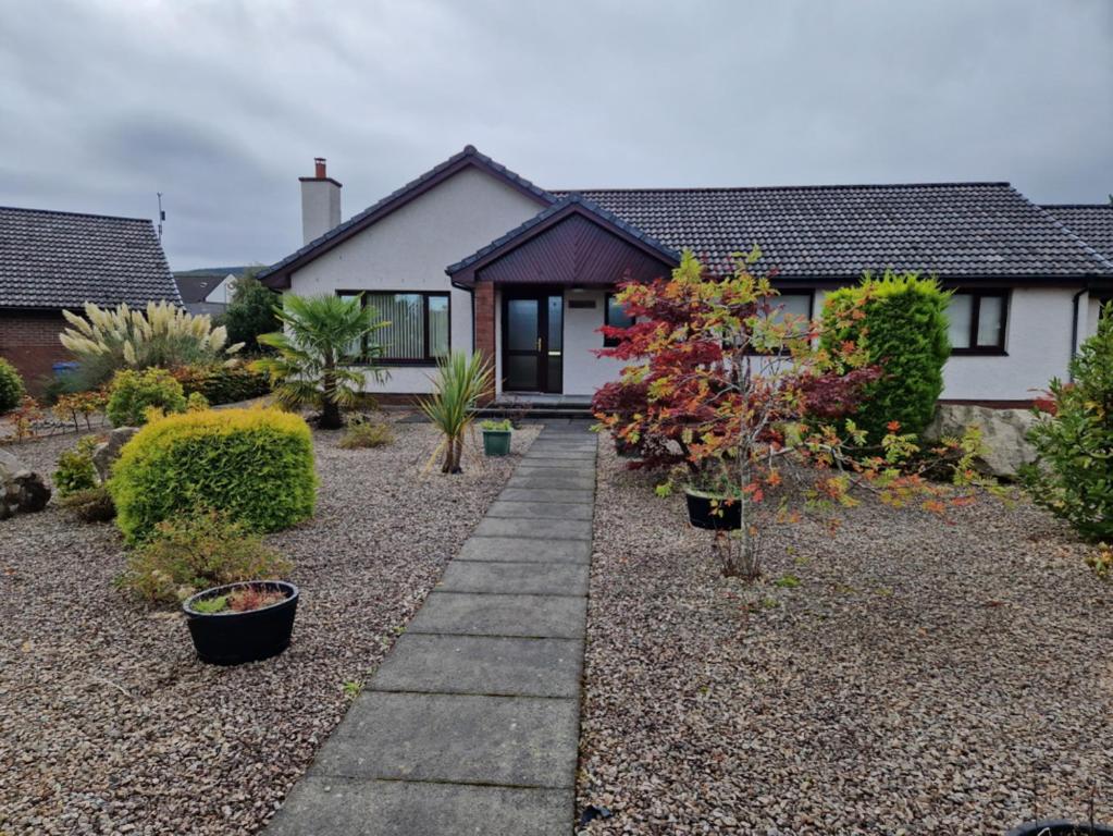 a house with a garden with plants in front of it at Brandane in Brodick