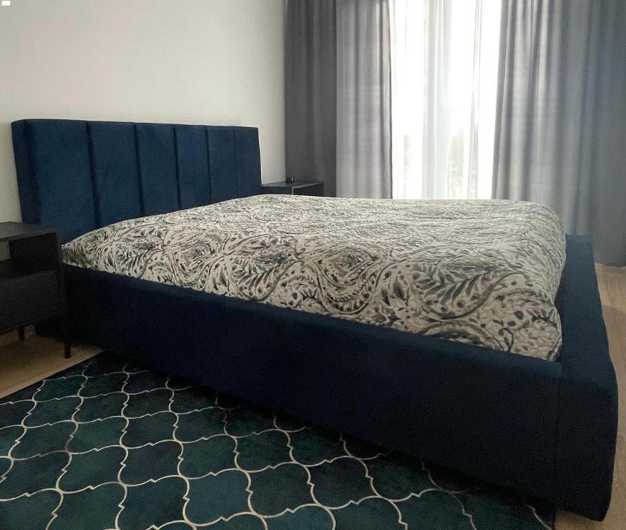 a bed with a blue headboard in a bedroom at pokojówka,WiFi,parking P in Poznań