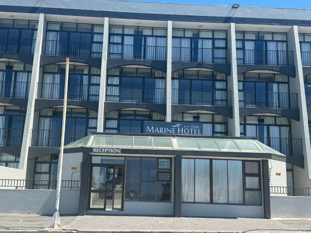 an office building with a sign for the managing hotel at Marine Hotel in East London