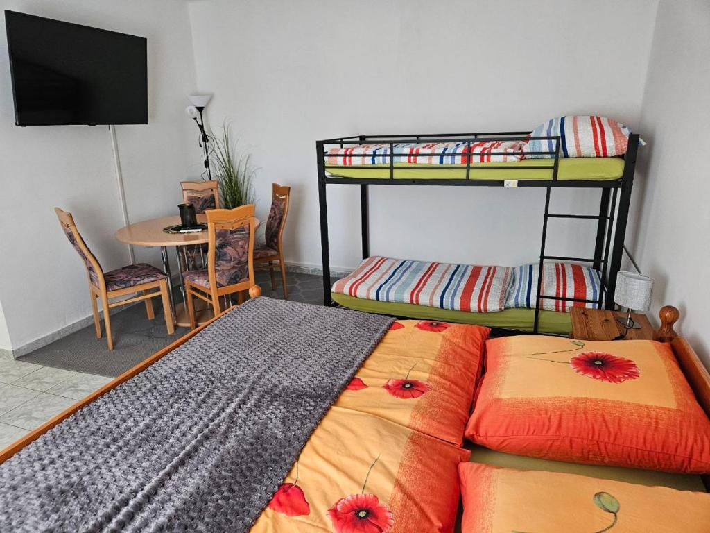 a bedroom with two bunk beds and a table at BiRo-Apartments in Zalavár