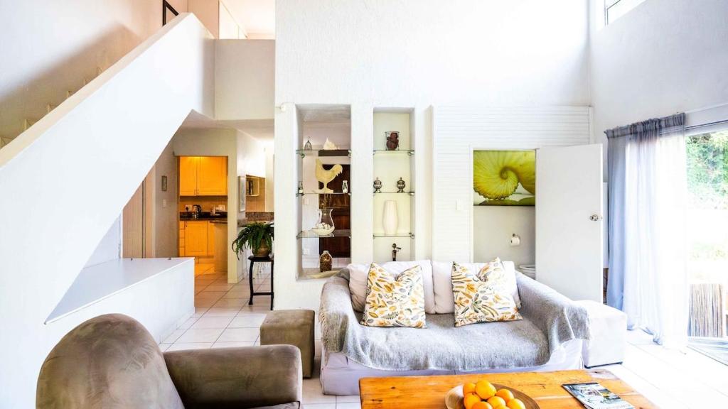 a living room with a couch and a table at Beach Forest Lodge - Milkwood in Ballito