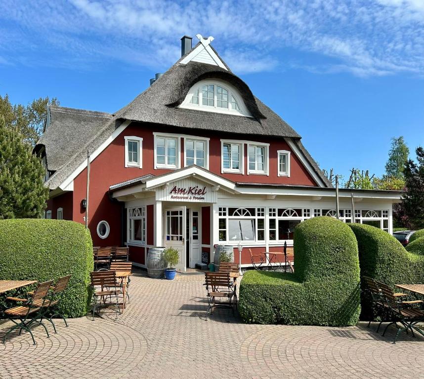 a large red building with chairs in front of it at Haus am Kiel in Ahrenshoop