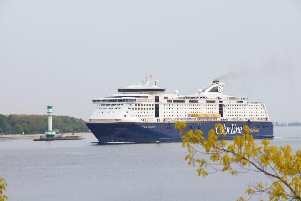 a cruise ship is docked in the water at StrandHotel Seeblick, Ostseebad Heikendorf in Heikendorf