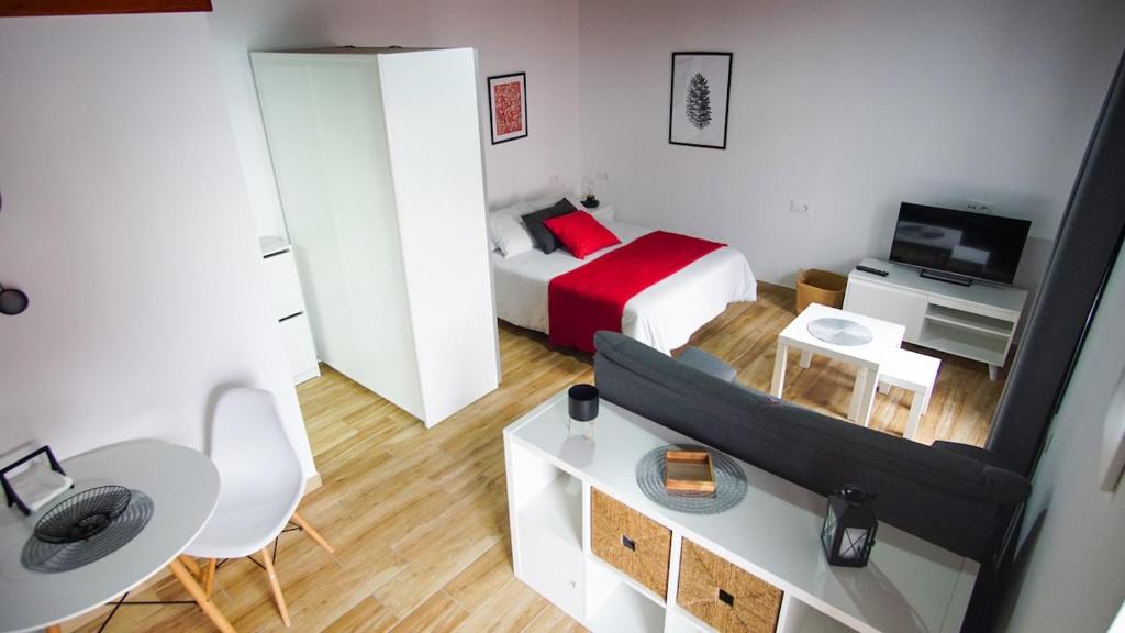 a small apartment with a bedroom with a bed and a table at Casita Las Lajas in El Paso