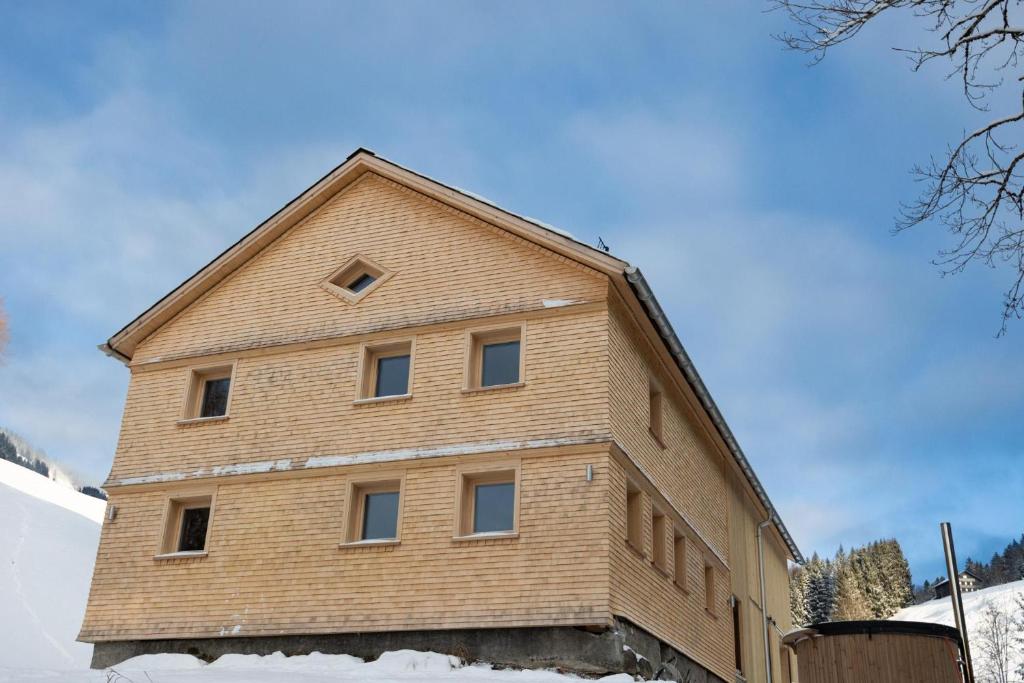 a large brick building in the snow at Hirschberg 231 in Bizau
