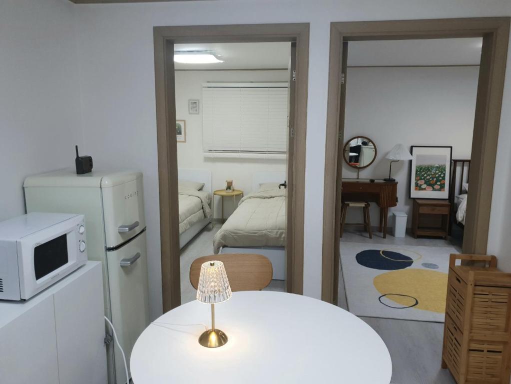a small room with a white table and a bedroom at K Hubhouse - Taereung stn 5min walk#villa 4pax in Seoul