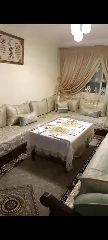 ein Wohnzimmer mit Sofa und Tisch in der Unterkunft Confort Flat in Salé