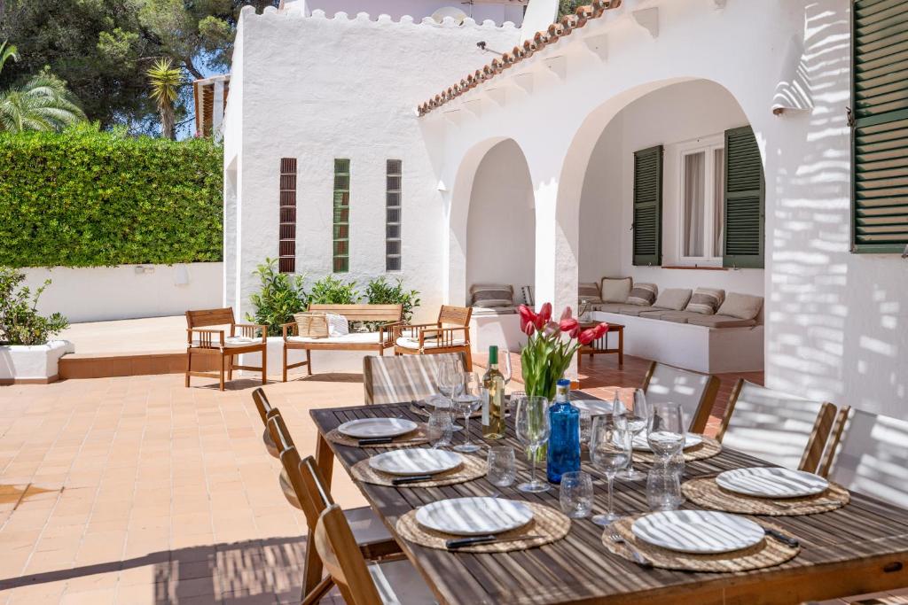 a wooden table with plates and glasses on a patio at Villa Linda by 3VILLAS in Son Parc