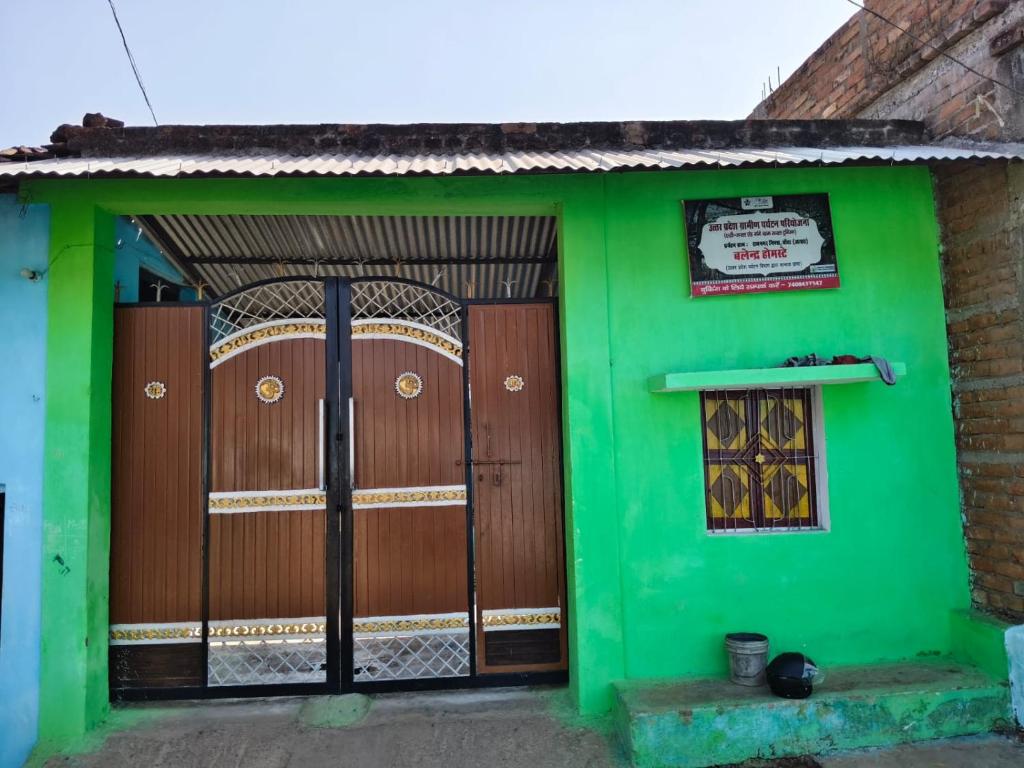 a green building with two doors and a window at Balendra Kumar in Tarahti