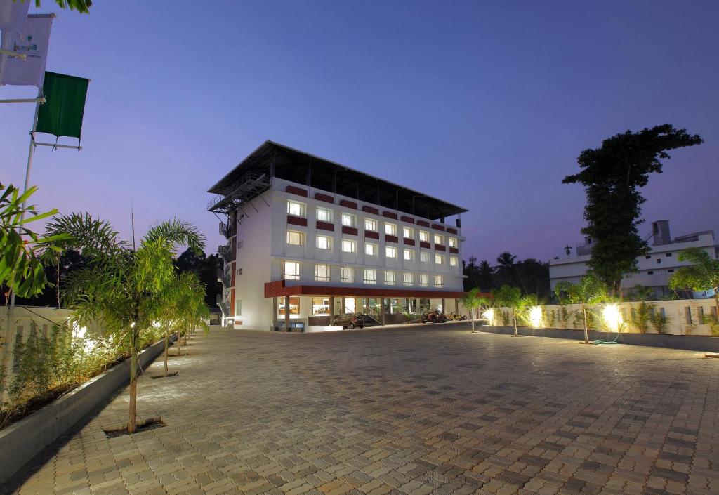 a large white building with a lot of windows at Hotel Indraprastha Kozhencherry in Kozhancheri