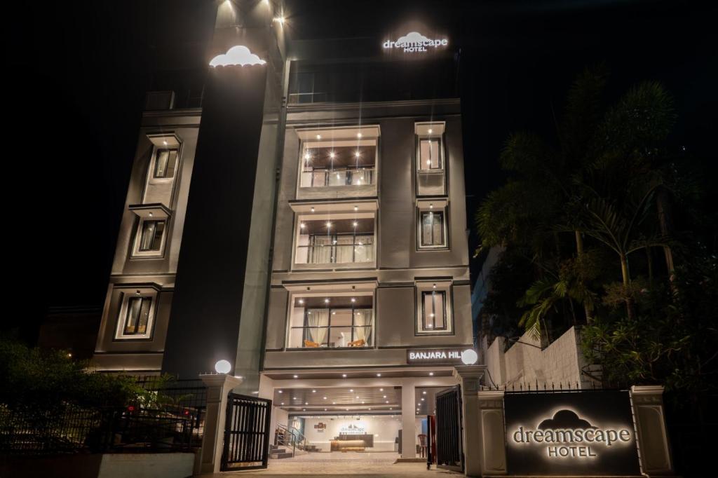a tall building with a sign on it at night at Dreamscape Banjara Hills in Hyderabad