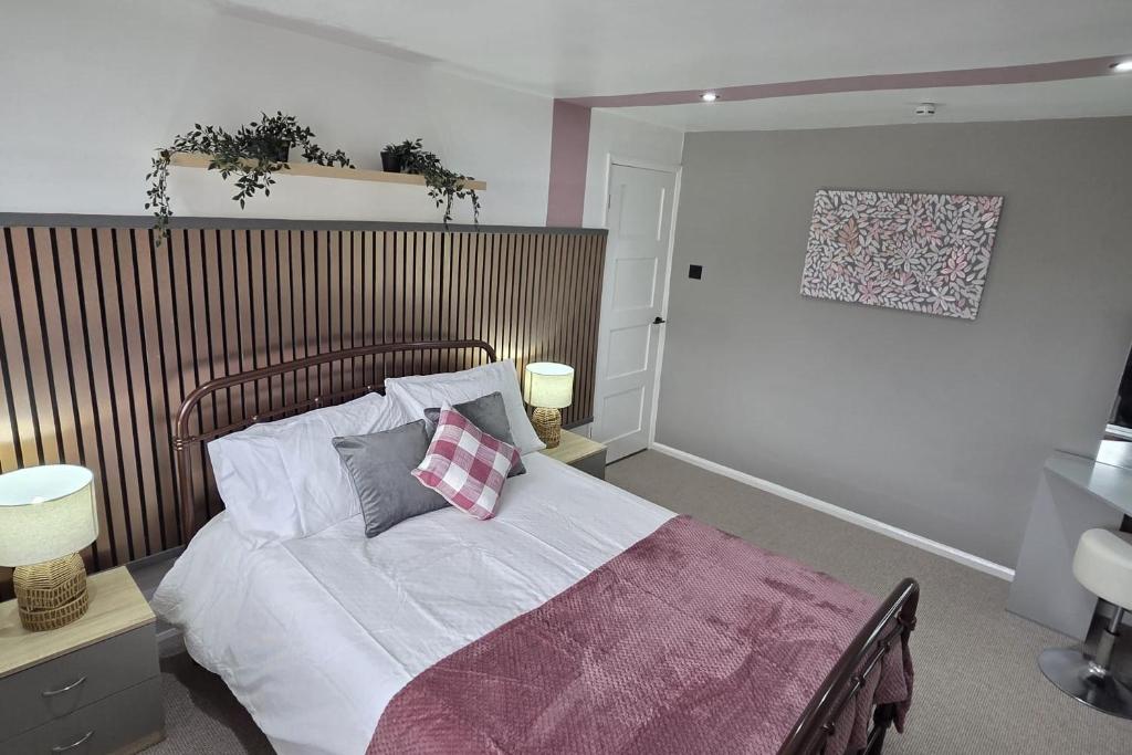 a bedroom with a bed with white sheets and pillows at Chester Charm - Spacious 3 Bedroom House in Chester