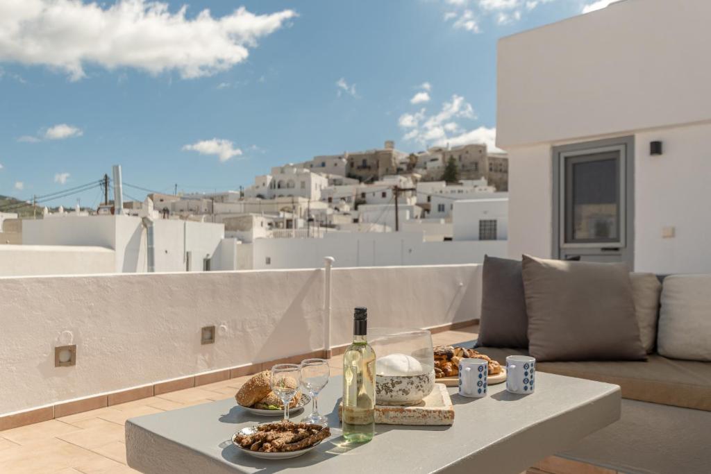 a table with food and wine on a balcony at Cozy Comfy Town House in Naxos Chora