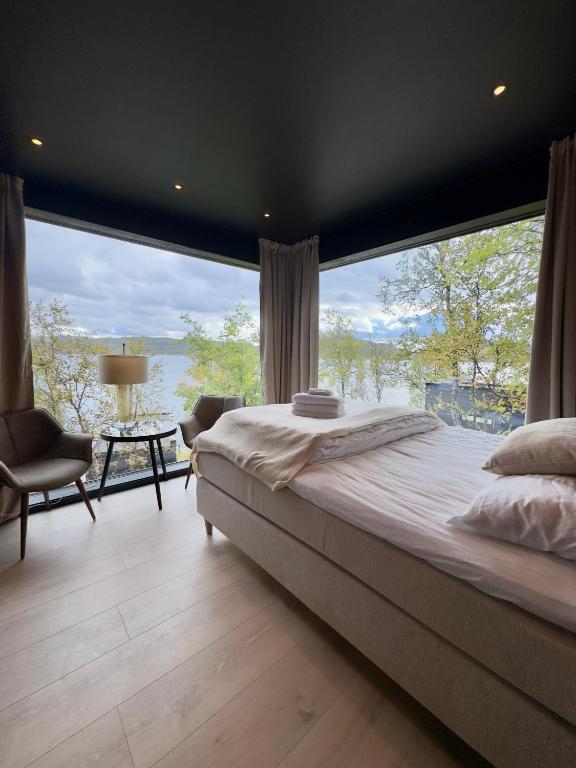 a bedroom with a large bed and a large window at Aurora Sea Lodges in Karpbukt