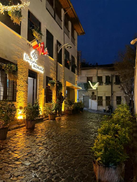 a cobblestone street in front of a building at night at Nisyan Konağı 1921 in Şahinbey