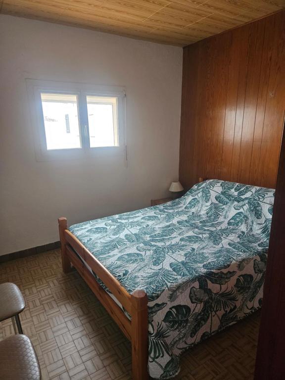 a bedroom with a bed with a blue blanket on it at bord de mer in Leucate-Plage