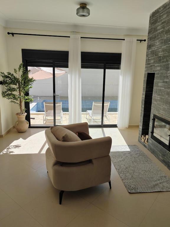 a living room with a chair and a fireplace at Villa Lila in Cherchell