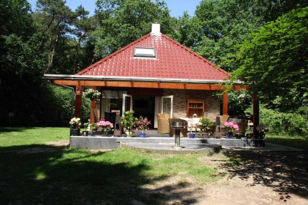 a small house with a red roof in a yard at Landhuis "Op de Heugte" in Norg
