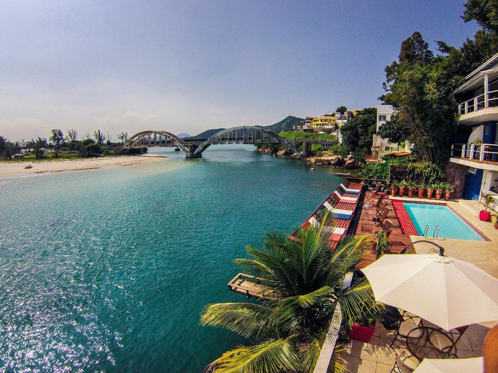 a view of a river with a bridge and a beach at Le Relais de Marambaia in Barra de Guaratiba