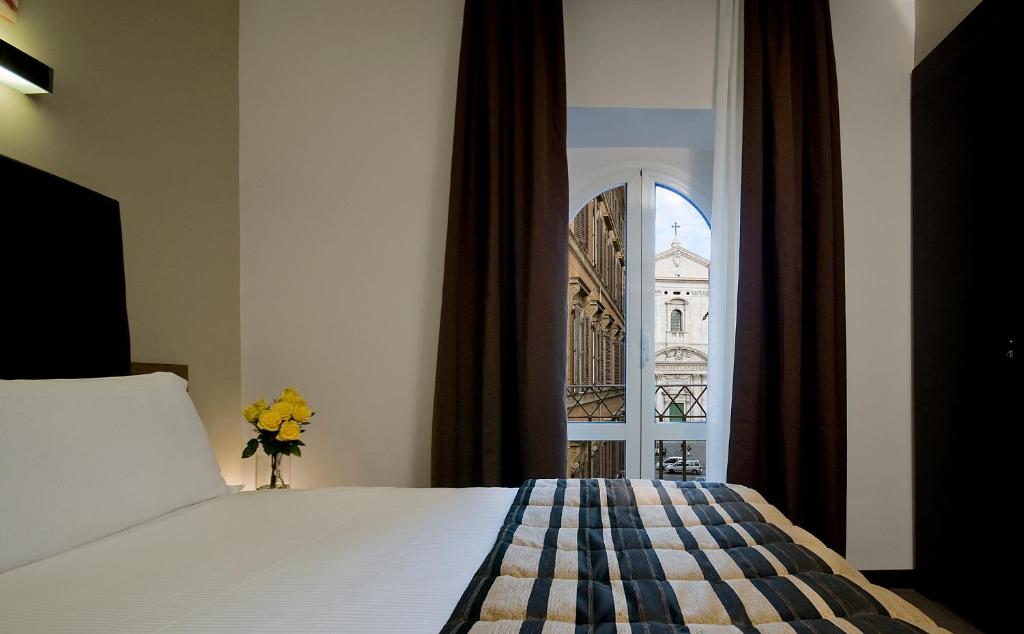 a bedroom with a bed and a view of a building at Hotel Rinascimento in Rome