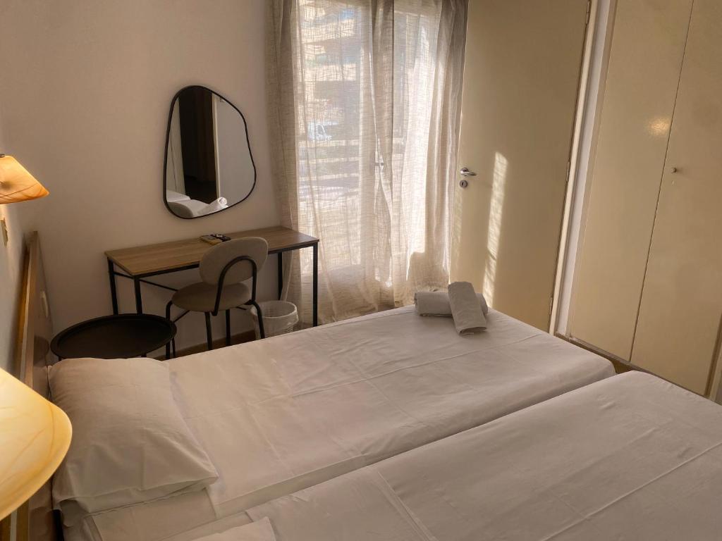 ein Schlafzimmer mit einem Bett, einem Schreibtisch und einem Spiegel in der Unterkunft Pasiphae Self Hotel in Heraklion