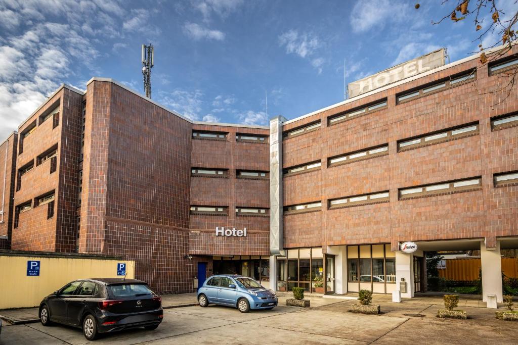 two cars parked in front of a brick building at Hotel Grunewald in Berlin
