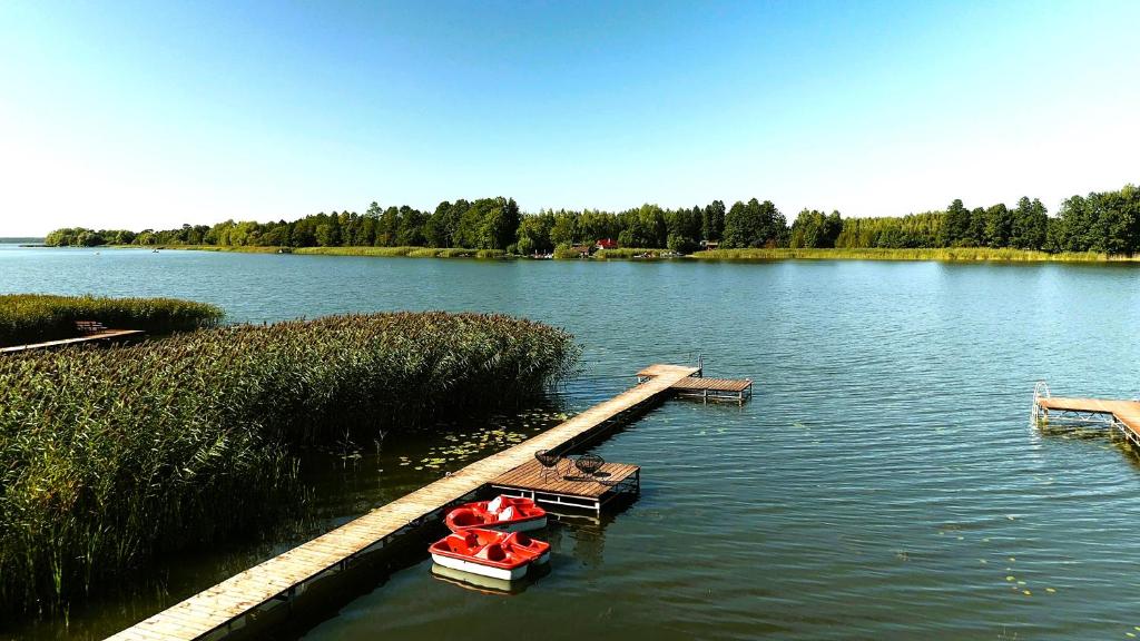 two boats are docked at a dock on a lake at Makosieje Resort-20m od brzegu,wi-fi ,widok na jezioro in Makosieje