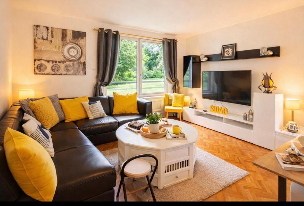 a living room with a couch and a tv at Grand appartement 5 pers avec parking proche du centre ville de Toulouse in Toulouse
