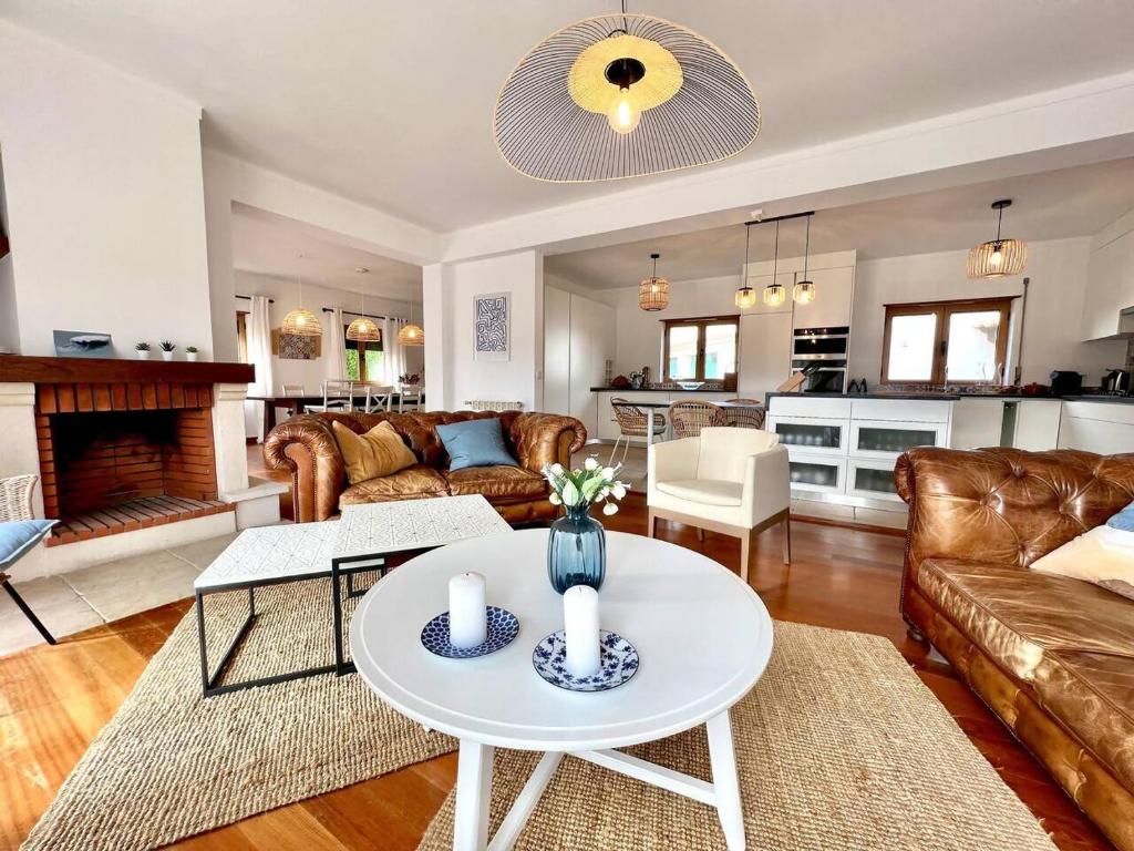 a living room with a couch and a table at Villa Mar & Surf • Piscina privada in Atouguia da Baleia
