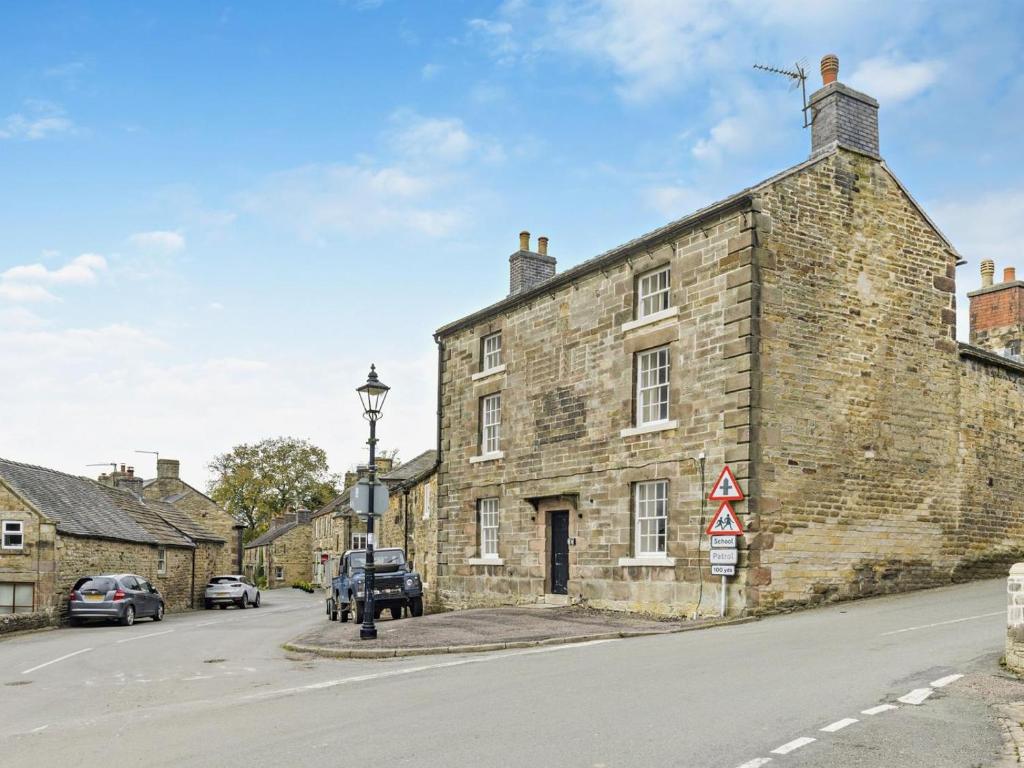 an old stone building on the side of a street at 6 Bed in Buxton oc-77369 in Longnor