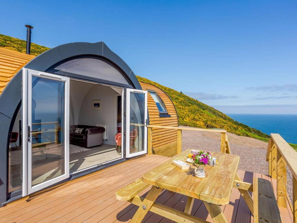 a tiny house with a deck and a table at 1 Bed in Tain oc-81338 in Nigg