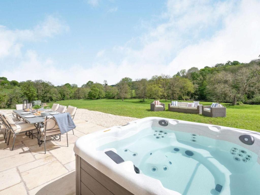 a hot tub on a patio with a table and chairs at 4 Bed in Wrexham oc-87675 in Chirk
